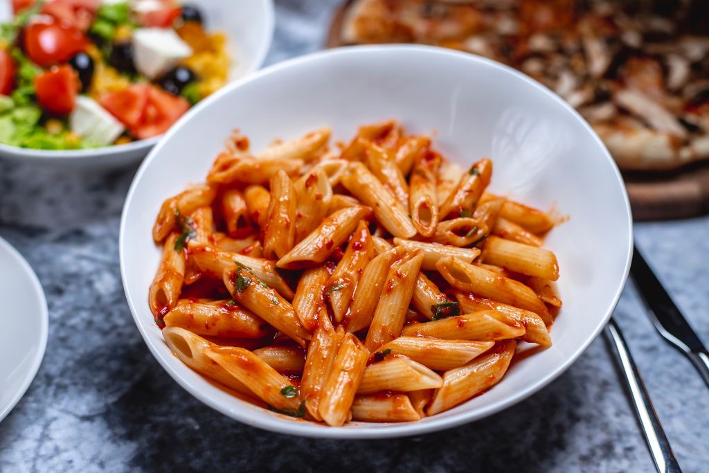 Close-up of cheesy Beefaroni Recipe from allrecipeworld showing gooey melted cheese and rich tomato sauce.